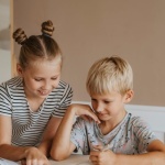 Lernen im Familien-Trubel: So gelingen Hausaufgaben, wenn das Geschwisterkind spielt